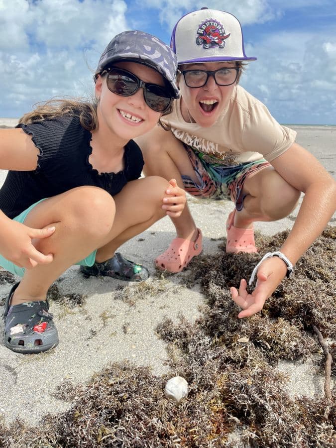 Amelie and her son crouched on the rocks by the water