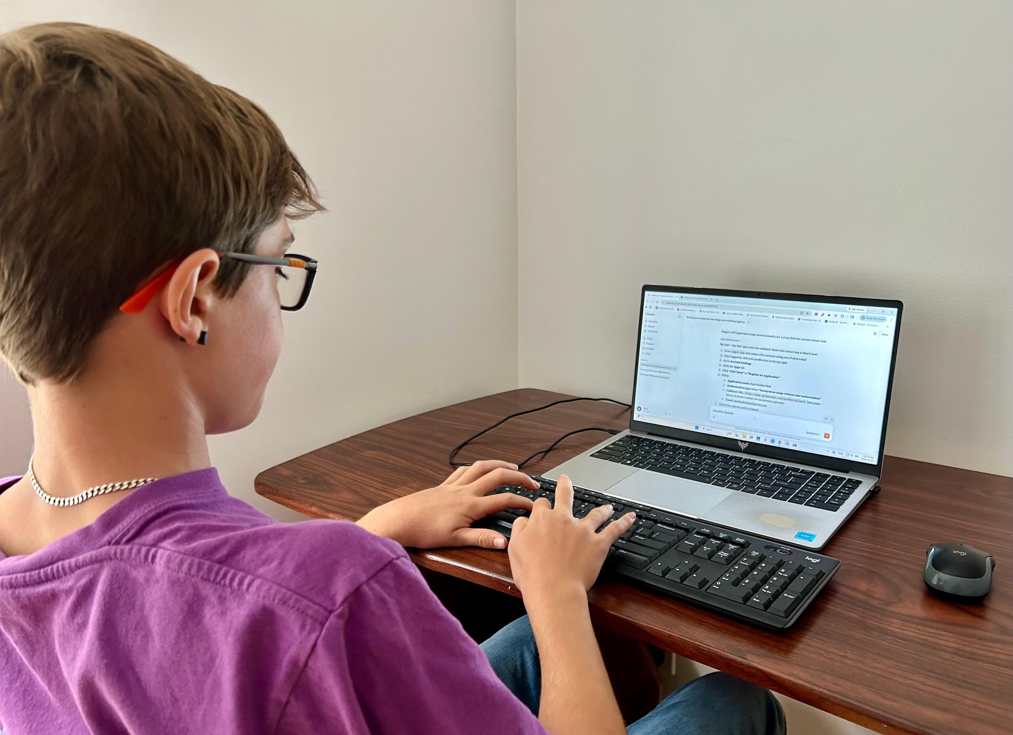 Parent and child sitting together looking at a laptop with curious expressions