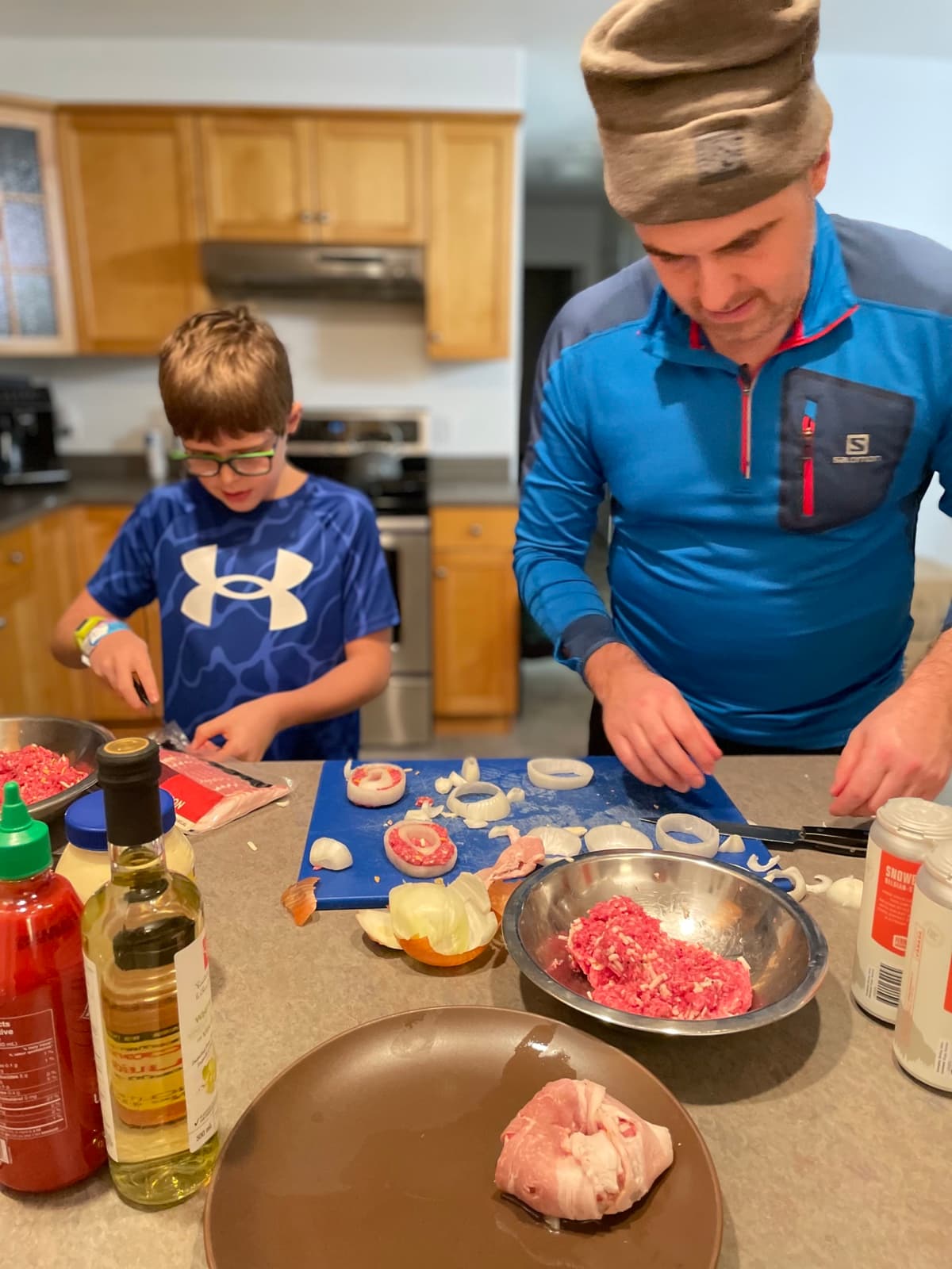 Zach chopping vegetables alongside his dad while prepping burgers from scratch