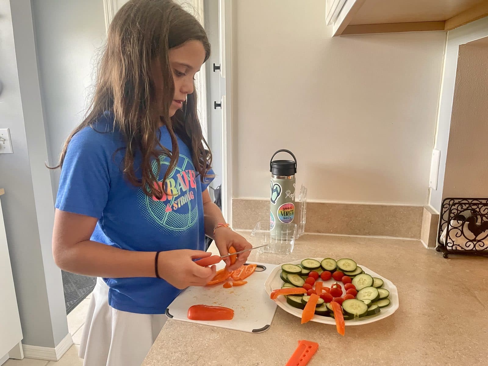 Julia independently cutting vegetables and preparing a veggie plate, real life skills in action