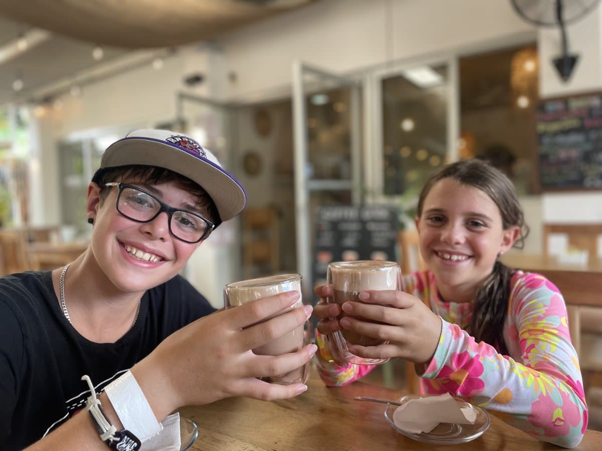 Zach and Julia at a café cheersing hot chocolates, a simple outing that resets everyone