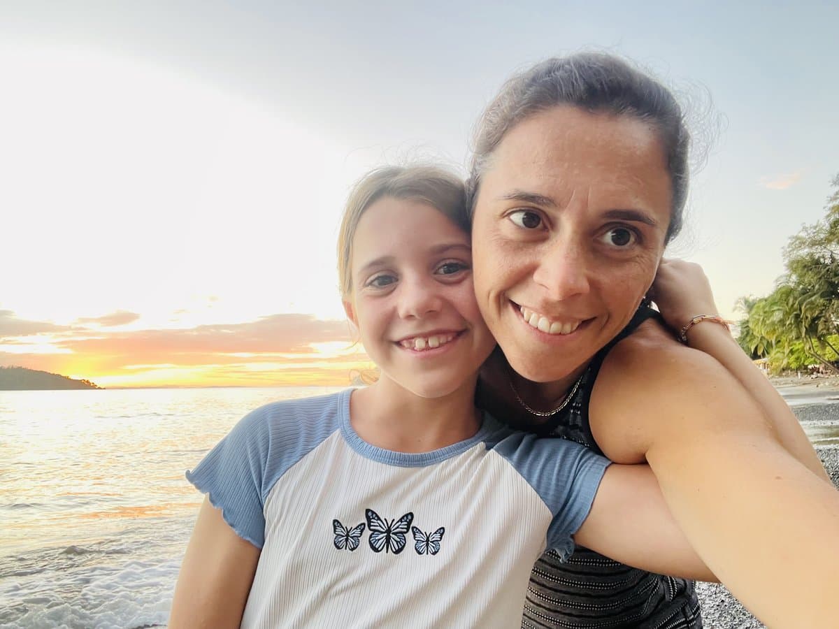 Mom and Julia in a sunset selfie on the beach, a moment of connection after a hard season