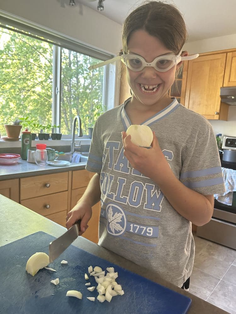 A boy chopping garlic for dinner