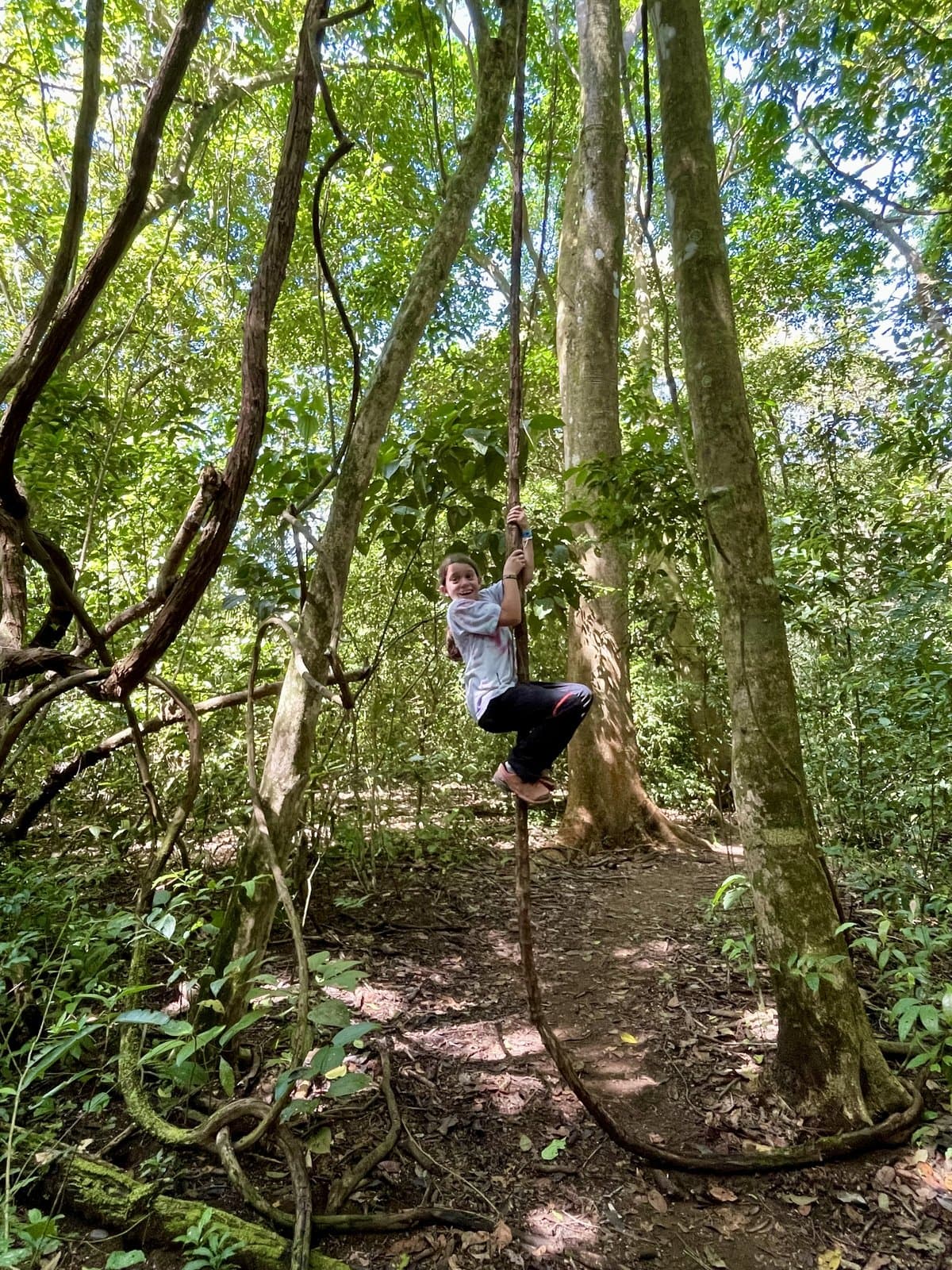 Zach swinging on a vine in the jungle, unstructured and kid-led exploration