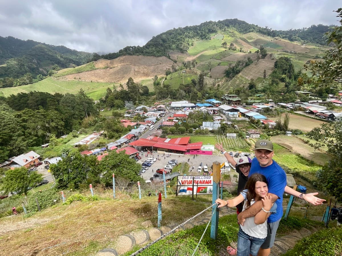 Family posing at a Panama mountain viewpoint overlooking a valley town