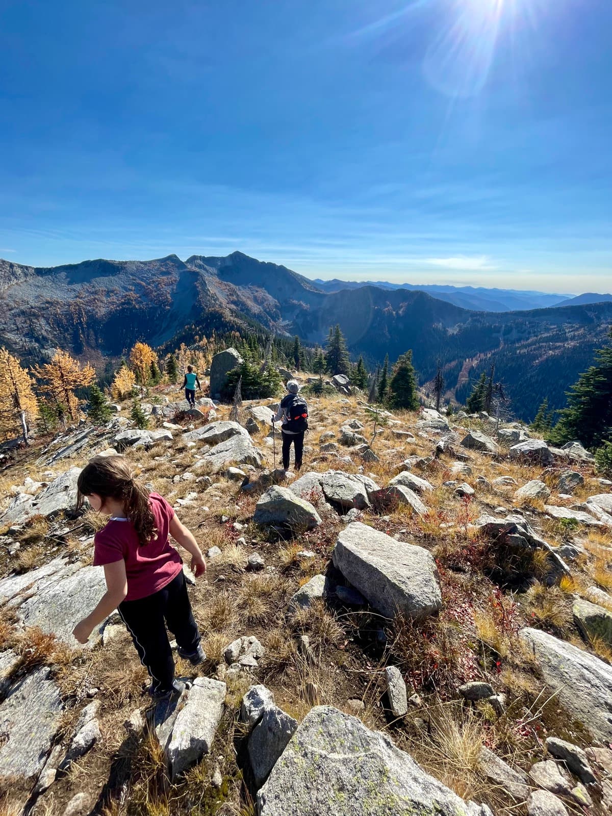 Family hiking a mountain ridge with panoramic views on a sunny day