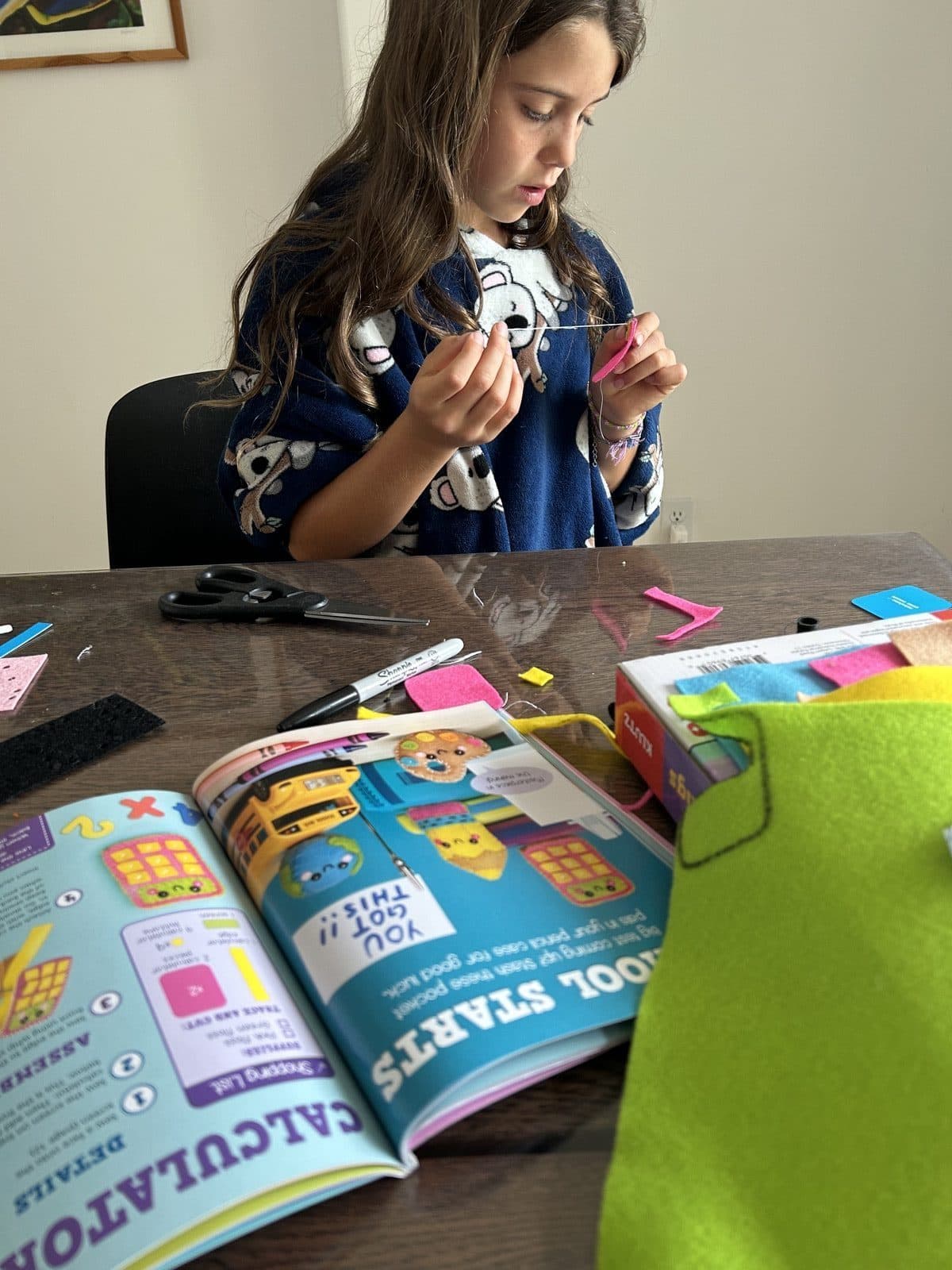 Kid working through a hands-on Klutz craft project at the kitchen table on a quiet afternoon