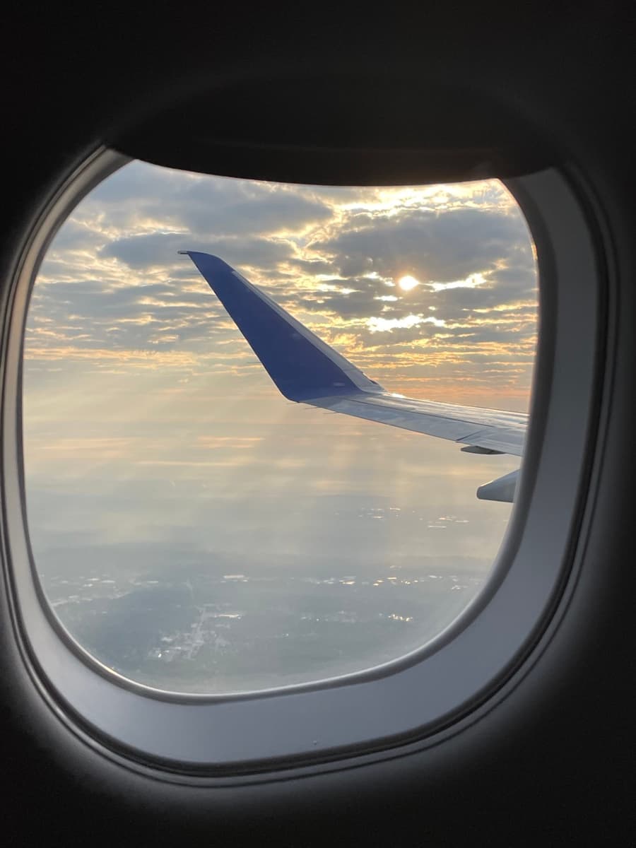 View through an airplane window at sunset, the start of another family adventure