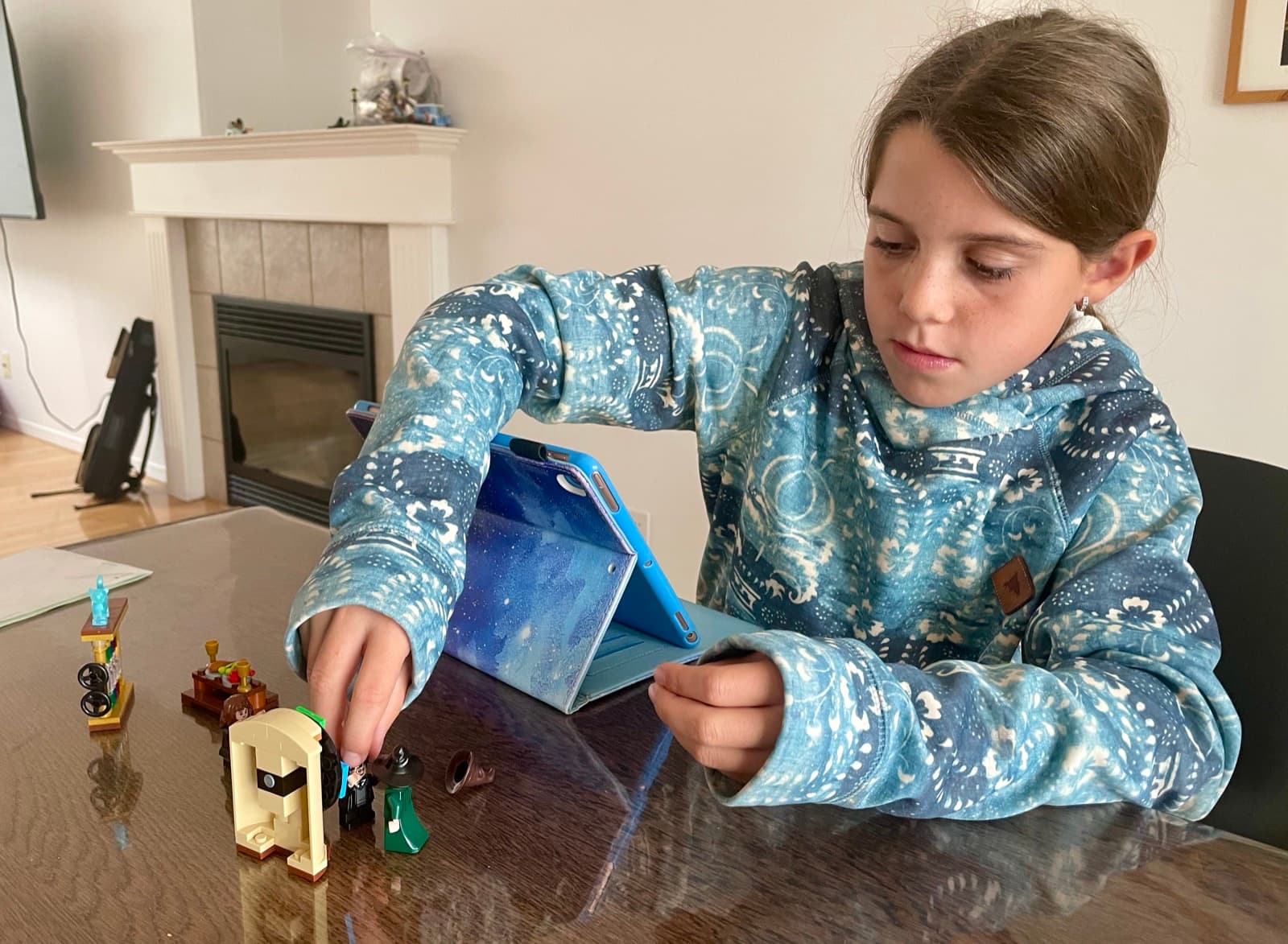 My daughter arranging small figures on a table for a stop-motion film, planning each frame by hand