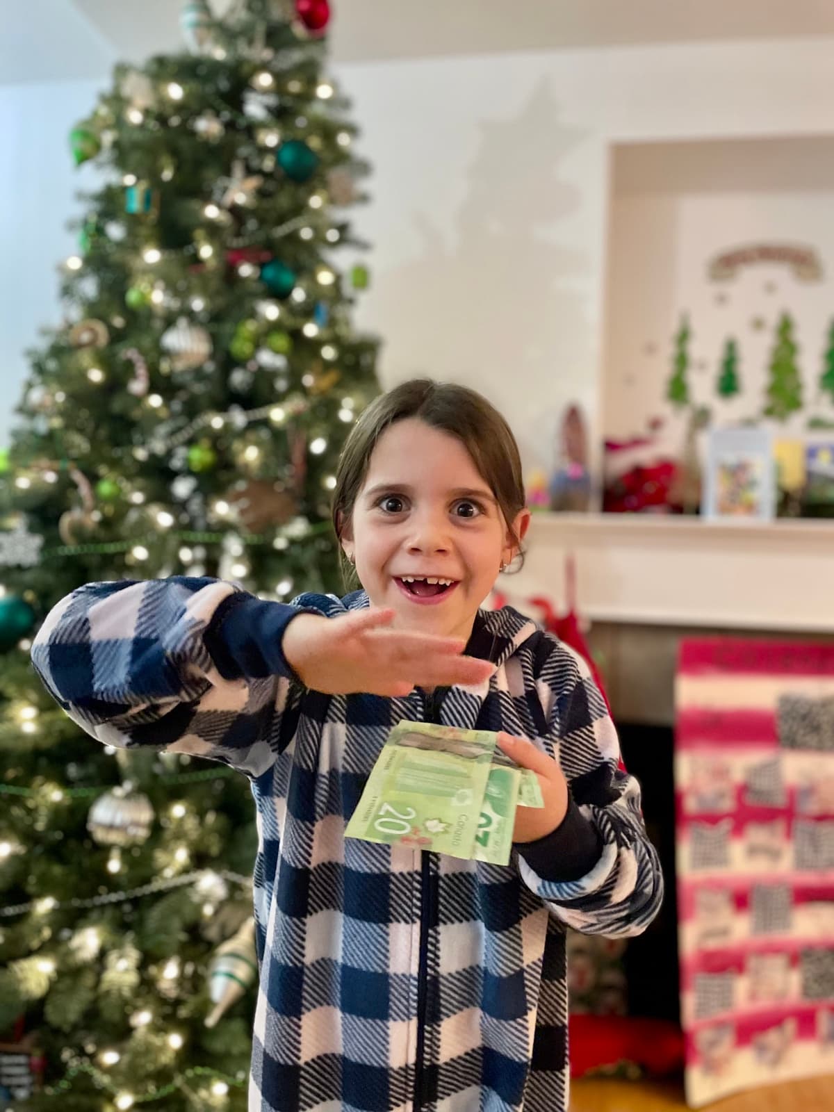 My daughter grinning and holding up a $20 bill with pure excitement