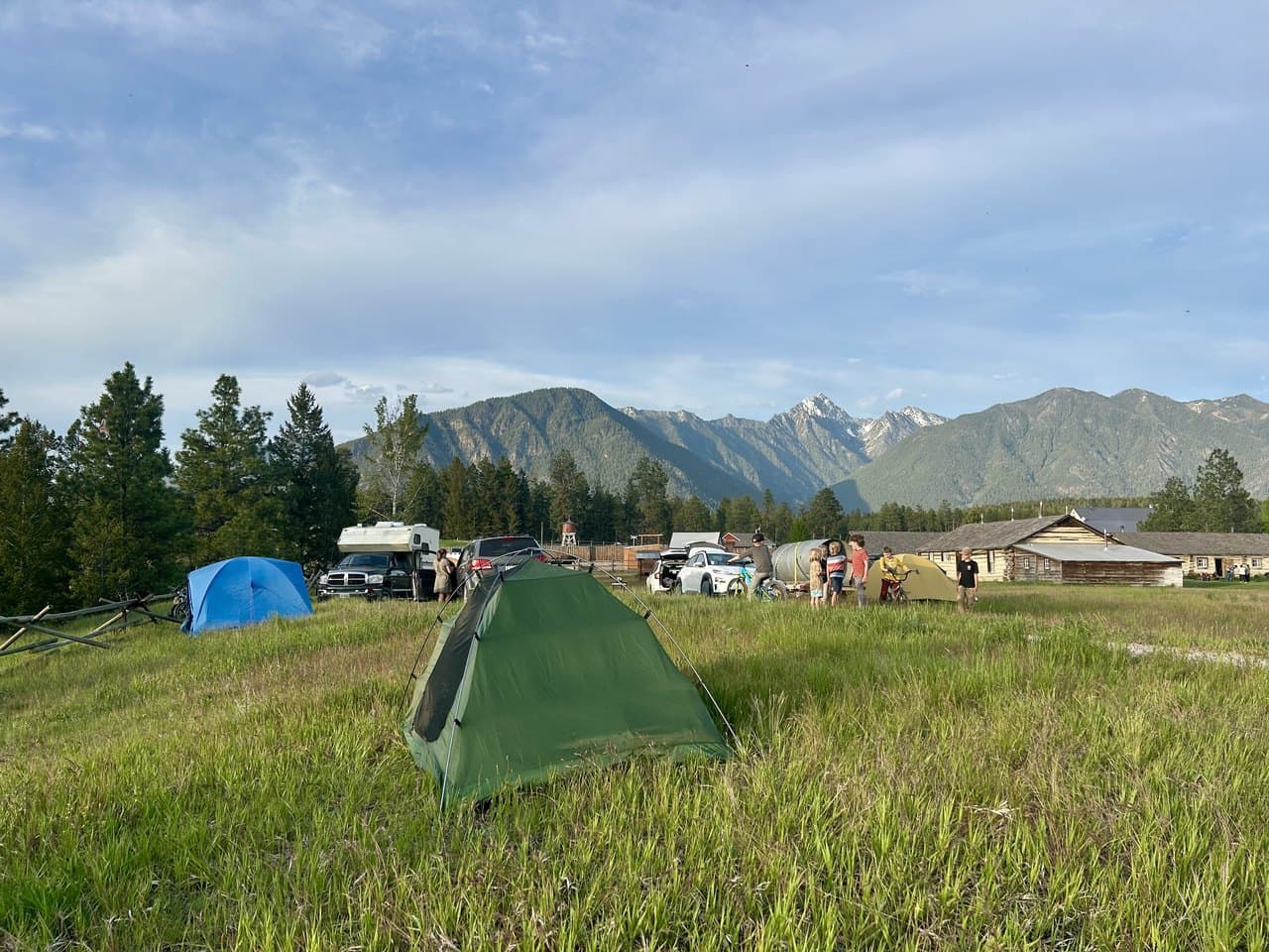 Tents set up in a mountain meadow at a Not Back to School camping trip, homeschool families gathered together at the start of the year