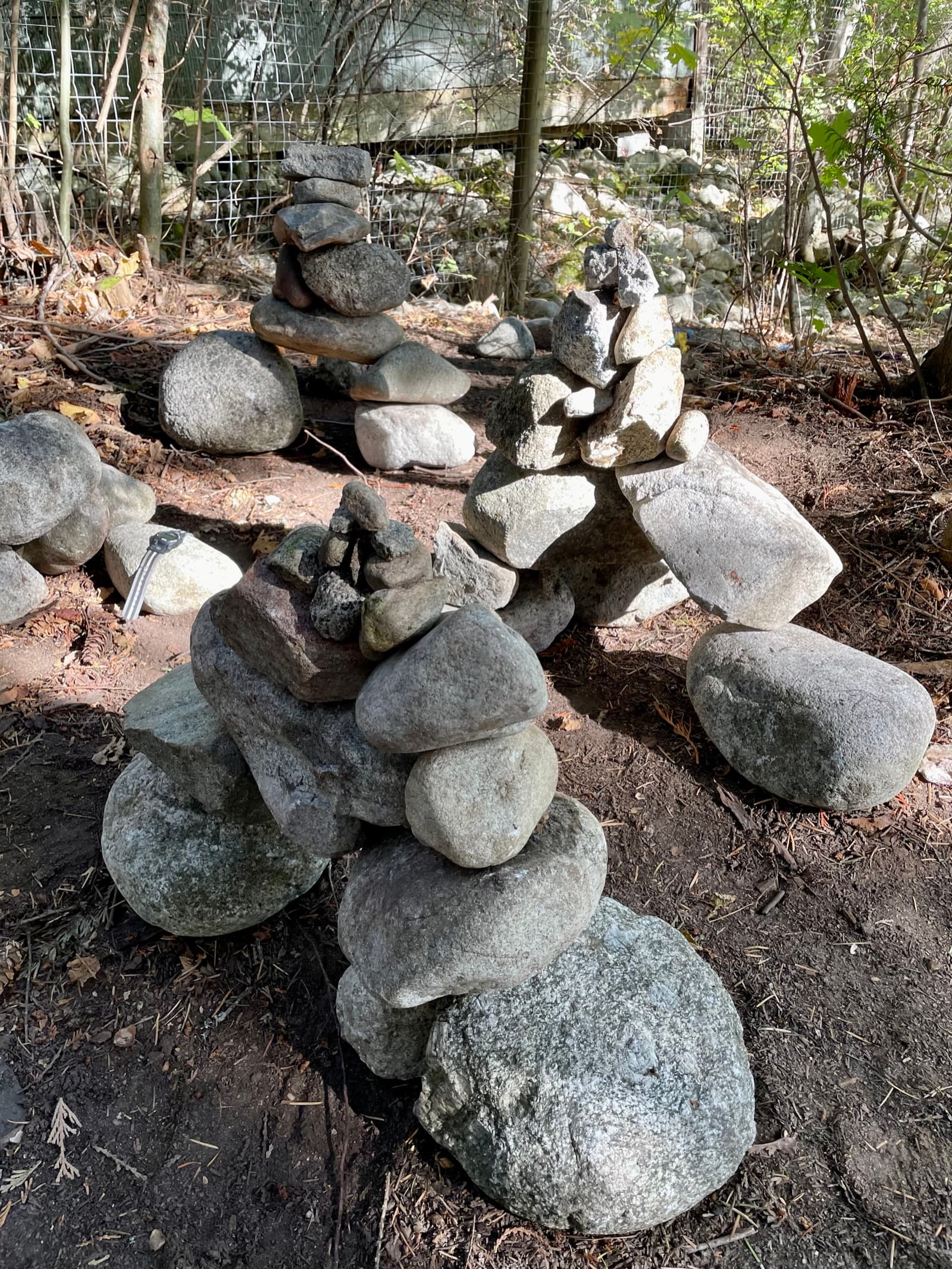 Stacked rock sculptures and inukshuks built in the forest, land art made from natural materials