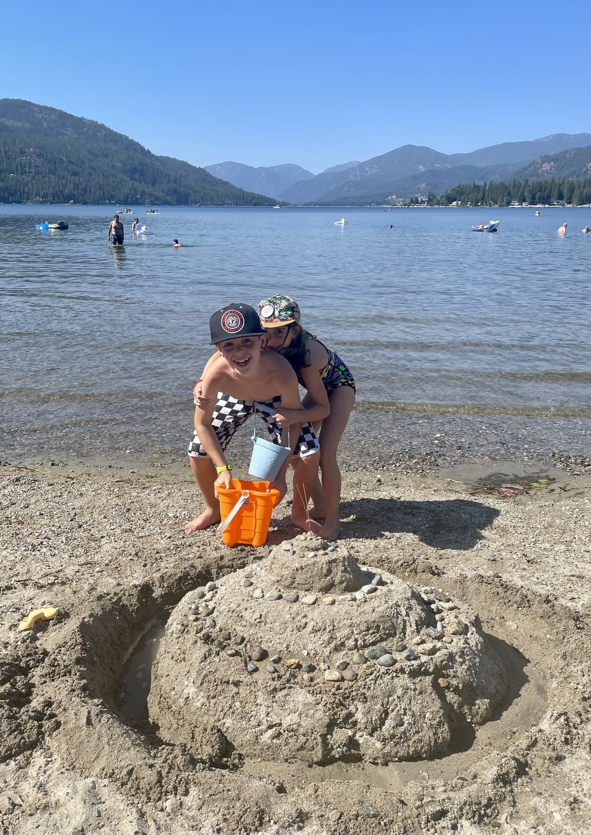 Zach and Julia building a sand castle together at the lake