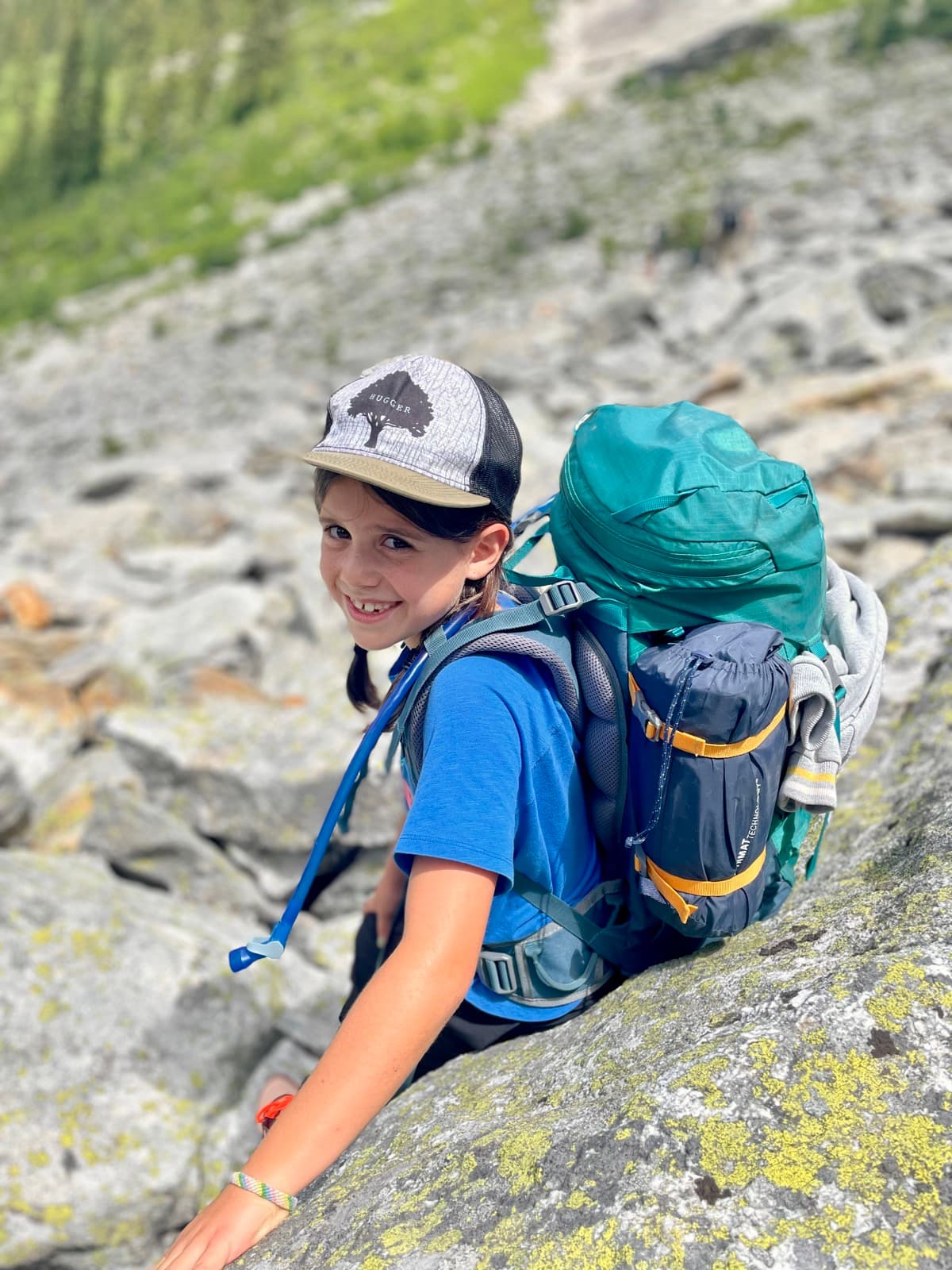 Kids navigating a challenging rocky trail section in the forest