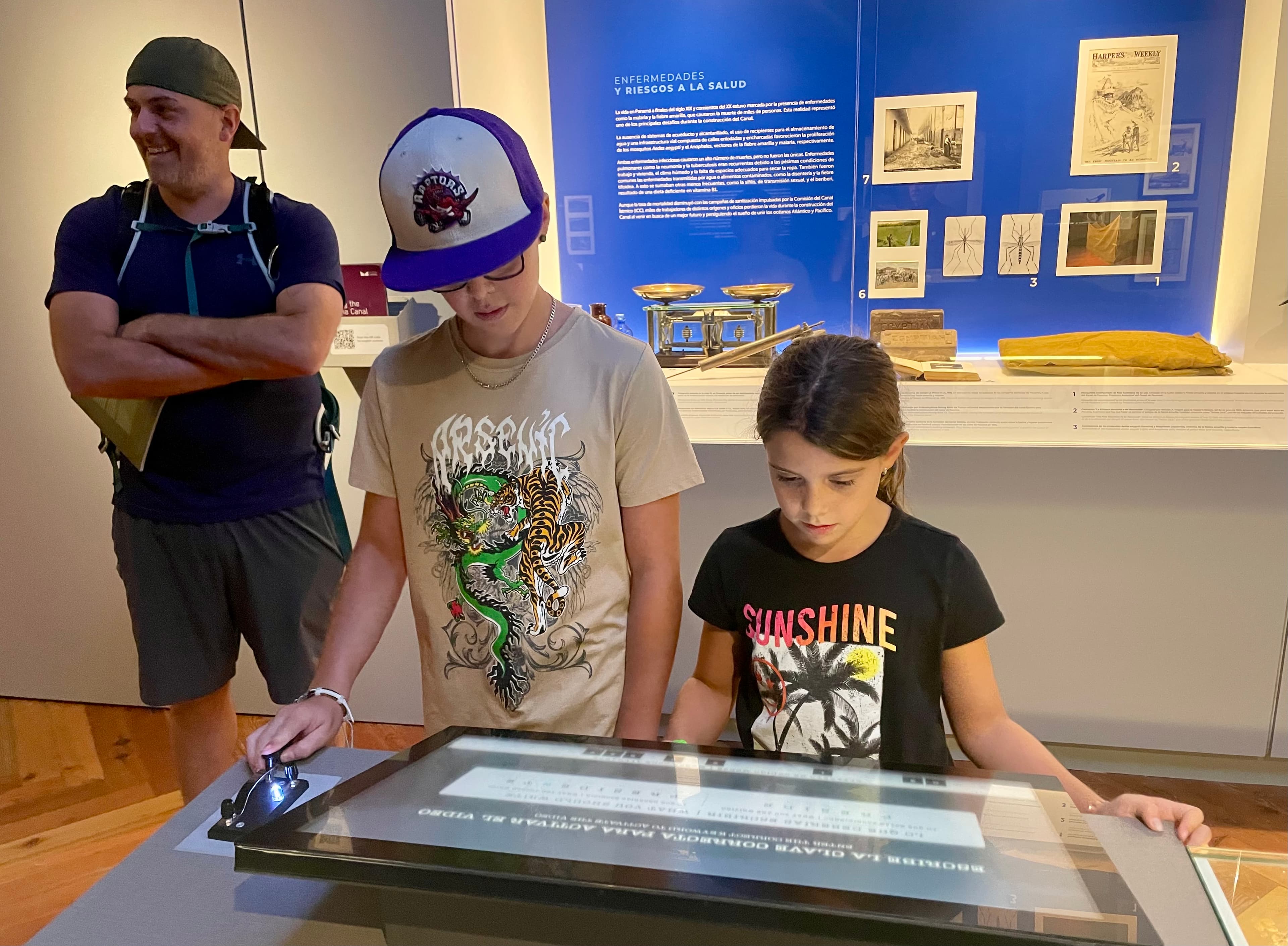 Family exploring an interactive museum exhibit together while travelling